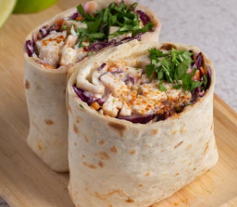 Merguez Melt wraps sliced open showing slaw and herbs
